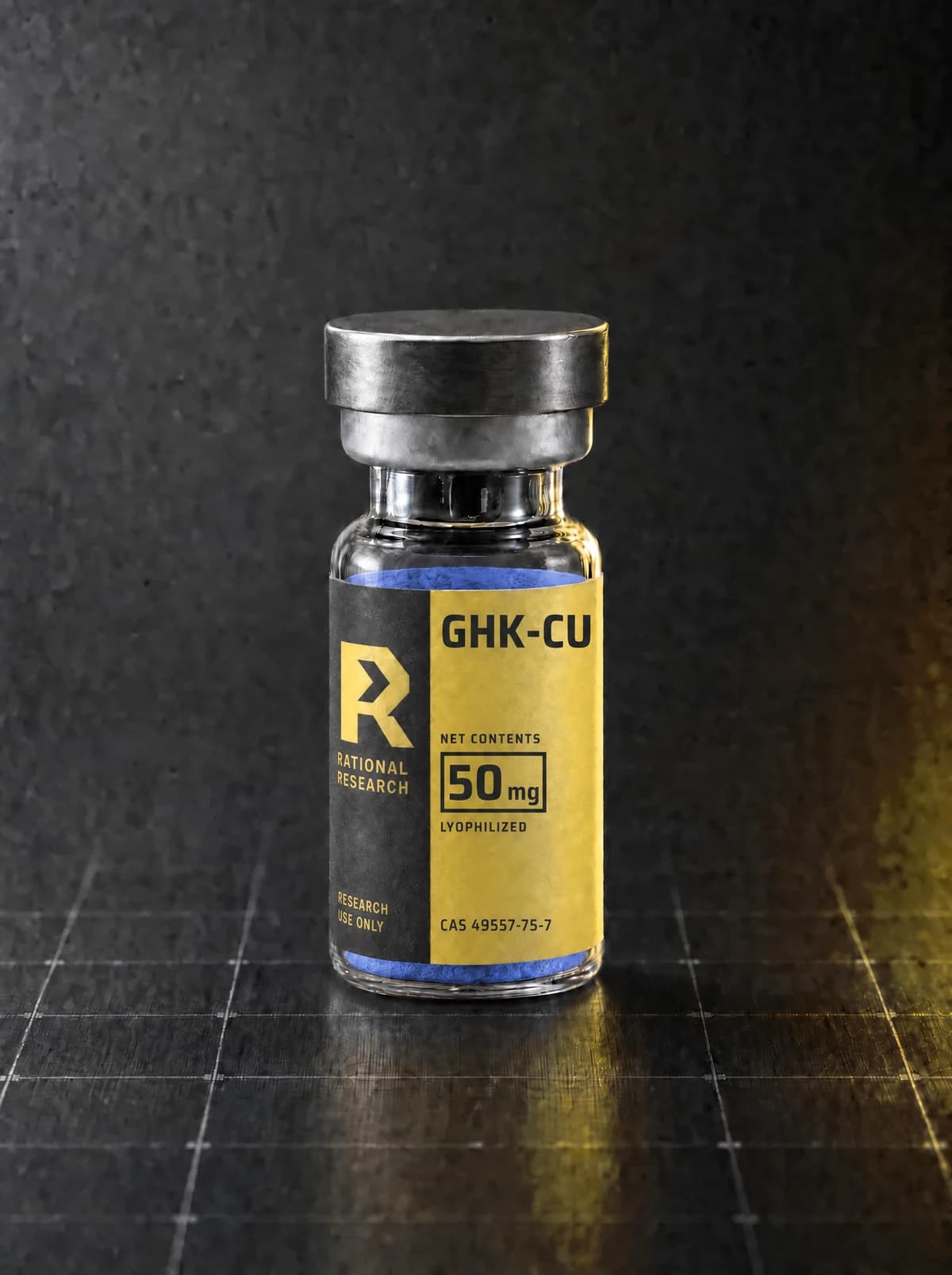 A sealed research vial carrying the printed Rational Research label for GHK-Cu, standing on a graphite panel